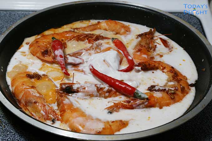 Shrimp cooked in pan with coconut milk and hot peppers.
