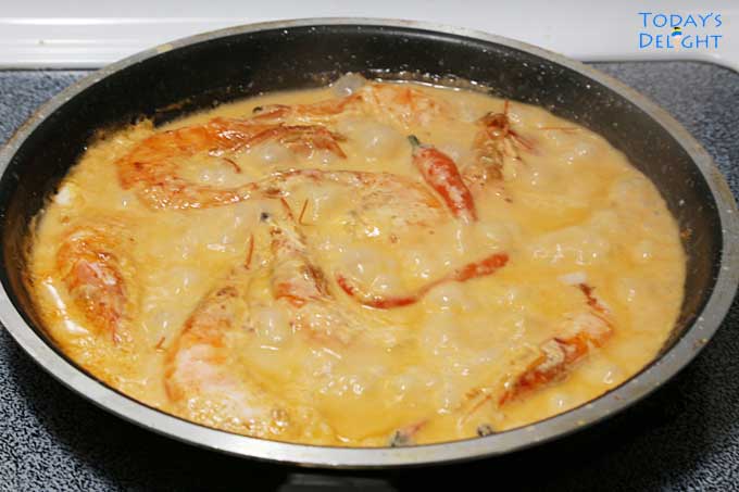 Shrimp in coconut milk in pan.