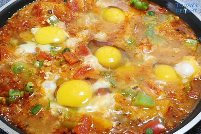 Eggs added in pan with shakshuka squash mixture.