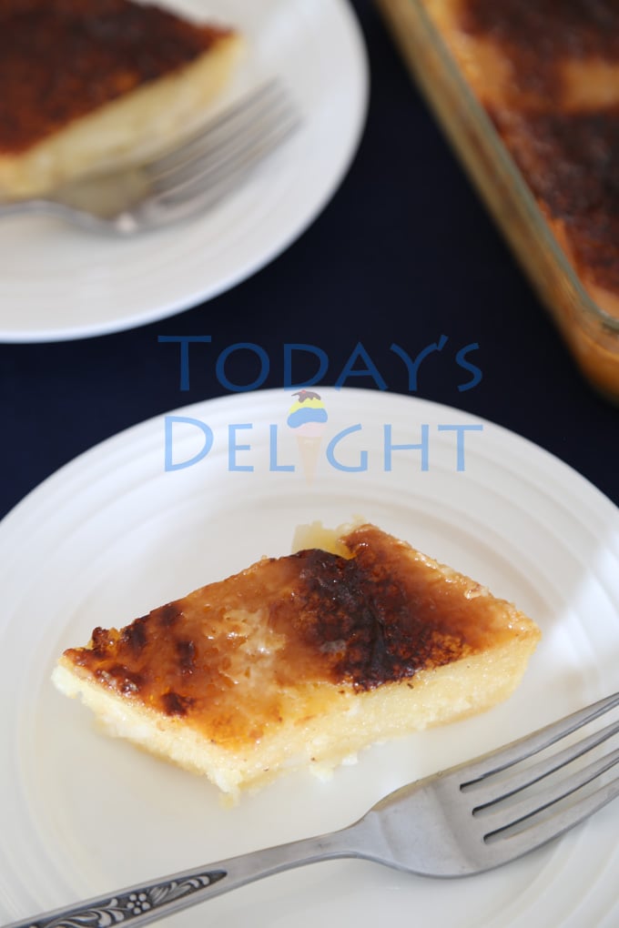 Two servings of cassava cake, a Filipino dessert with sweet golden to dark brown topping in two small plates and on the side is the cassava cake pan.