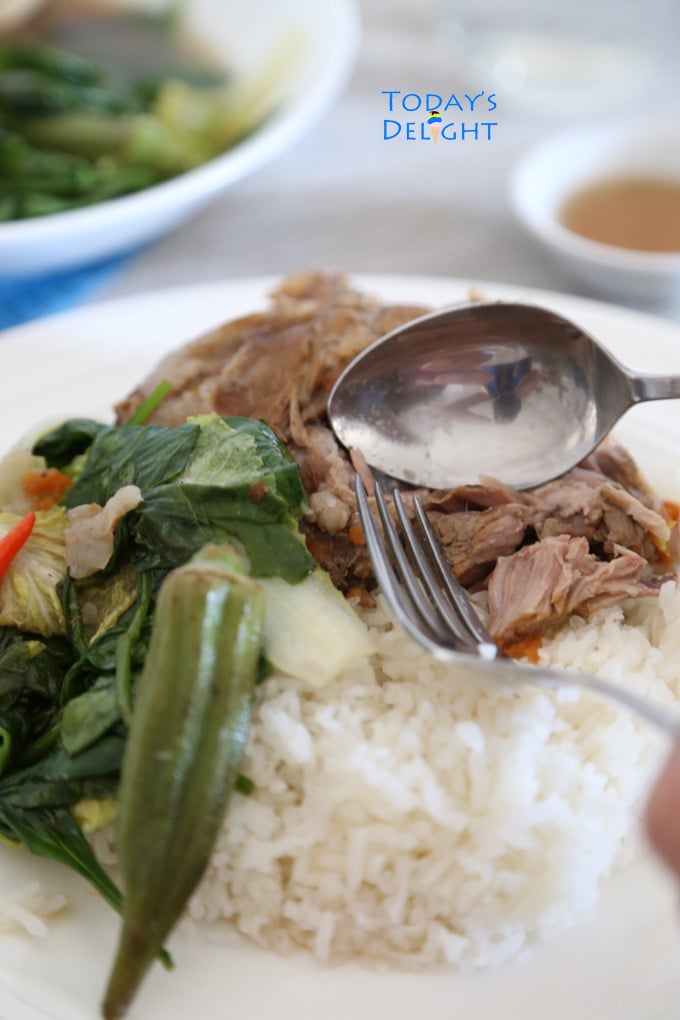 Filipino soup with pork and vegetables poured over white rice.