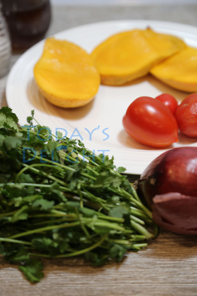 Cut mango and all ingredients on a plate and table.