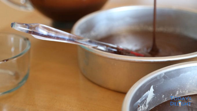 Chocolate cake batter divided into 3 pans.