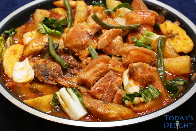 Pork and chicken pochero in a pan is a Filipino stew in tomato based with pork, chicken, vegetables and plantain banana.