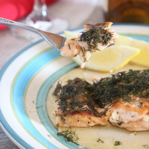 Salmon with lemon and dill on a fork and plate.