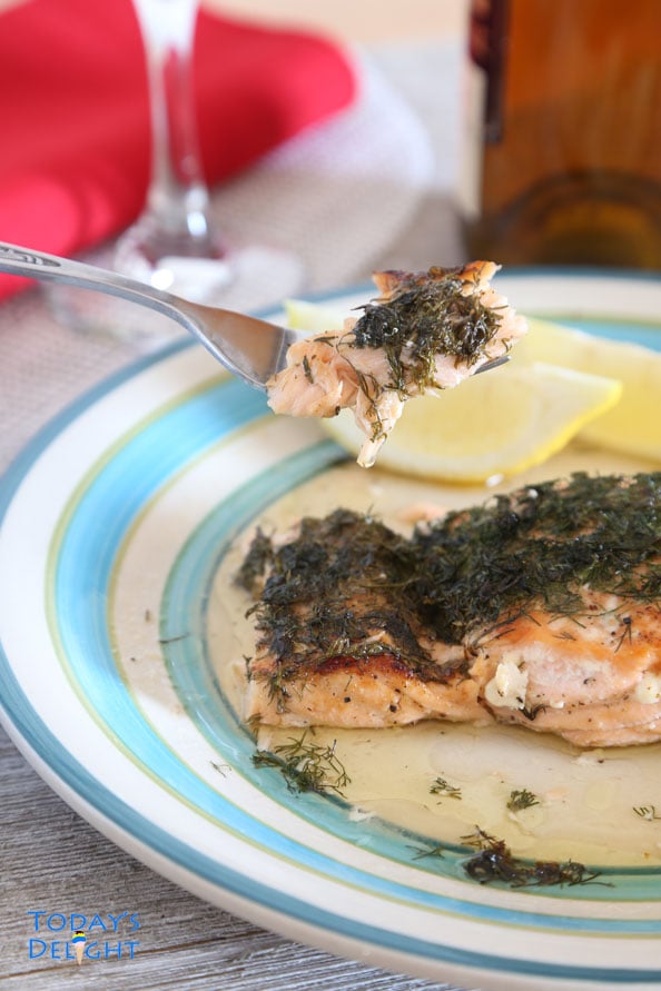 Salmon with lemon and dill on a fork and plate.