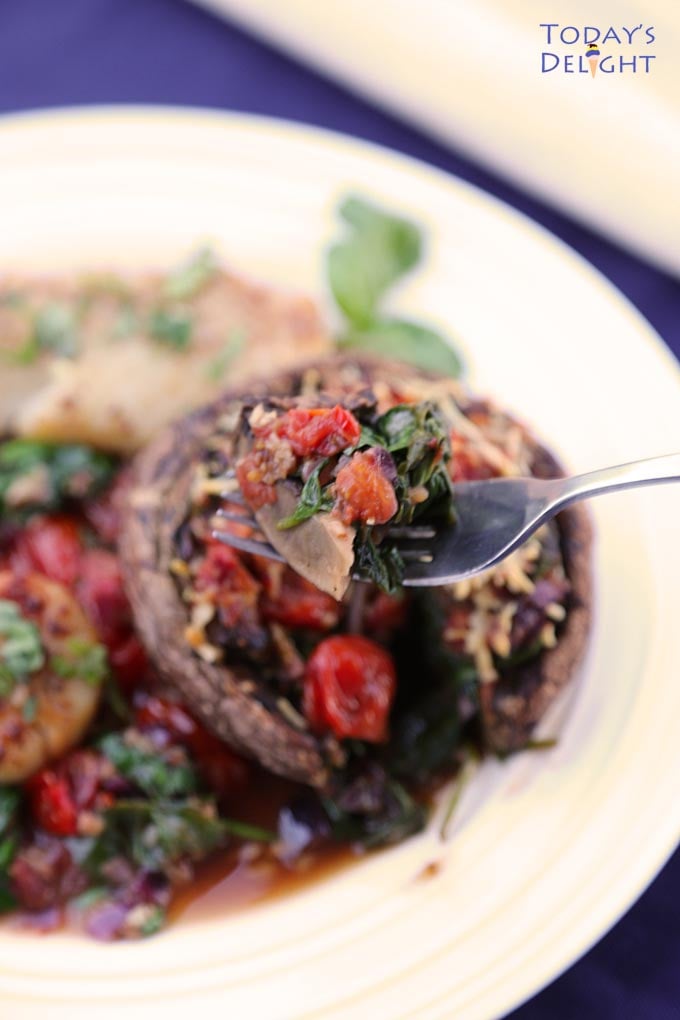 Digging into the spinach stuffed portobello mushroom stuffing with fork.