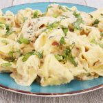 Cheese tortellini with basil cream sauce on a plate.