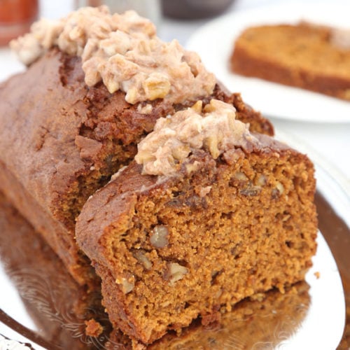 Sliced pumpkin spice bread with cream cheese frosting.