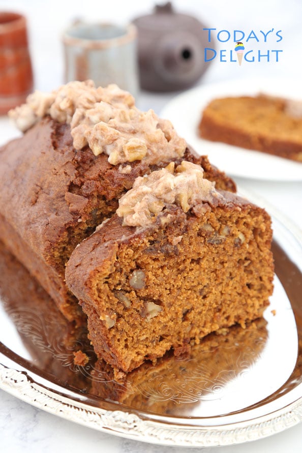 Sliced pumpkin spice bread with cream cheese frosting.