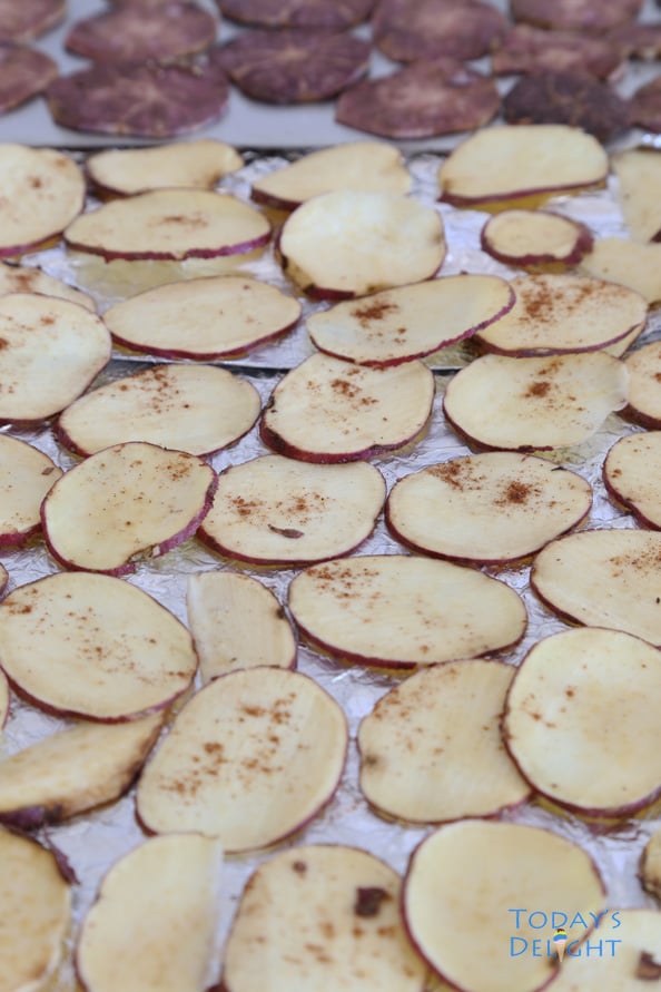 Raw sweet potatoes on a baking tray.