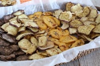 Baked pumpkin spice banana chips and sweet potatoes on a tray.