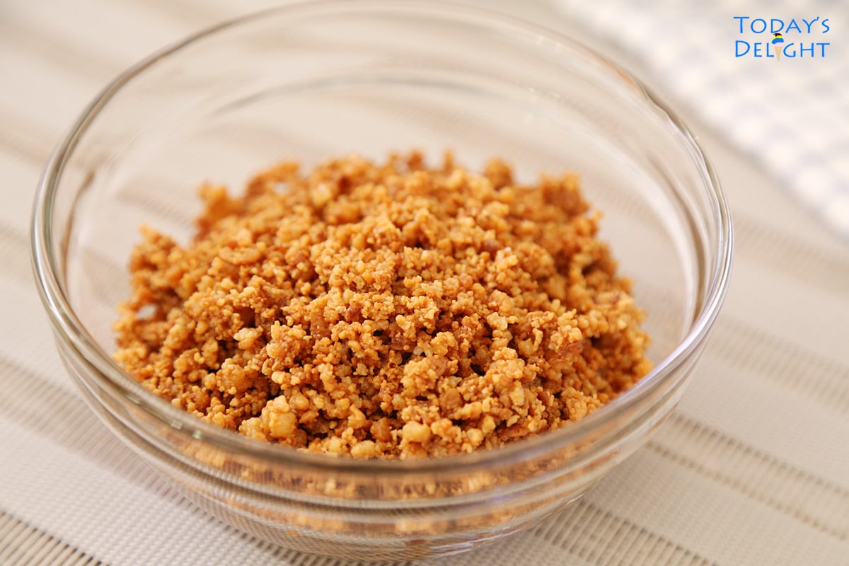 Light golden brown latik (toasted coconut curd) in a bowl.