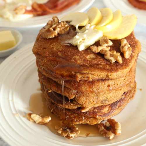 Layers of krusteaz pumpkin spice pancake with walnuts, apple slices and pancake syrup.