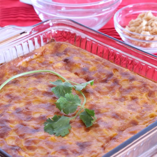 Easy baked corn casserole in glass baking pan garnished with parsley.