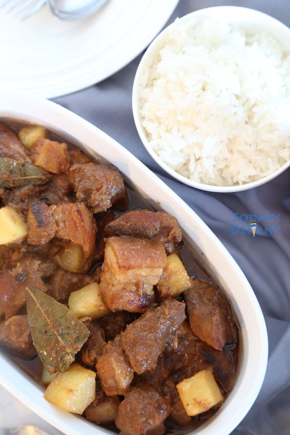 Pork with pineapple in a platter and a side of white rice.