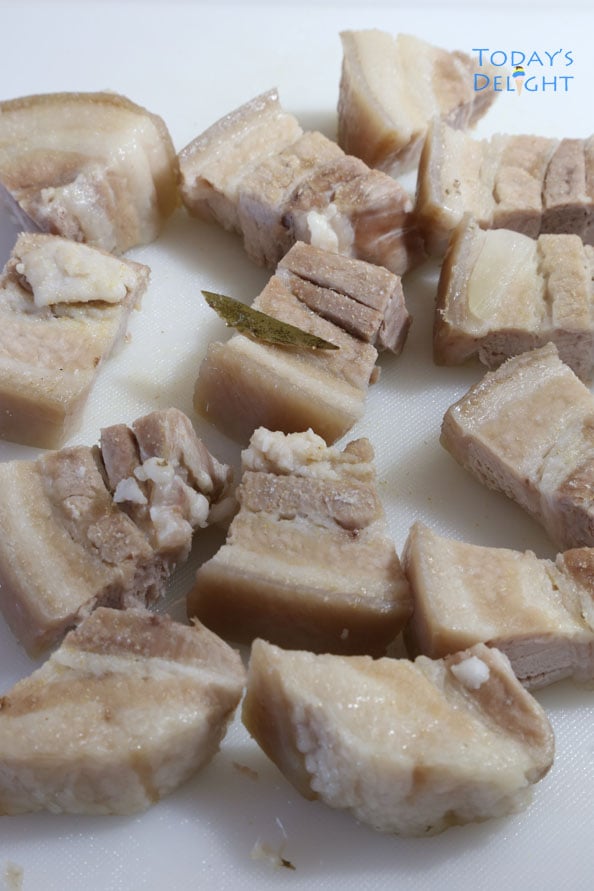 Boiled and sliced seasoned pork belly (lechon kawali) on a cutting board.