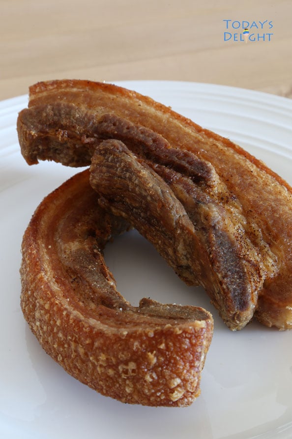 Two whole fried pork belly (lechon) on a plate.