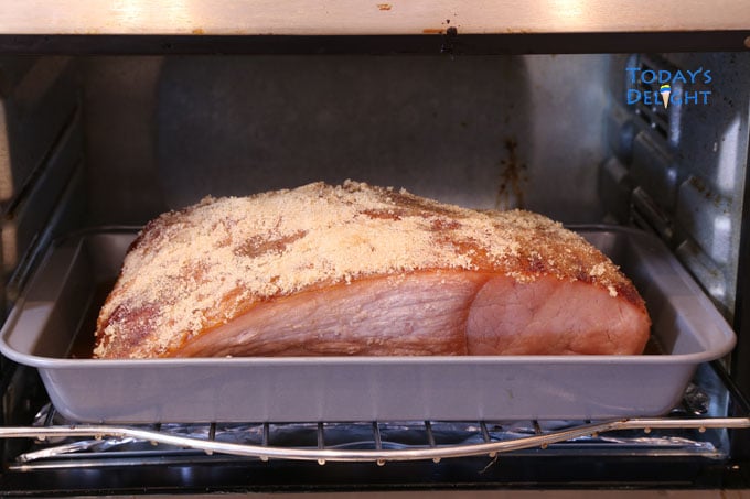 Carver ham with brown sugar glazing on a pan in the oven.