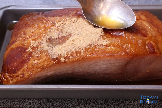 A spoon dabbed against carve ham to help melt brown sugar glazing.