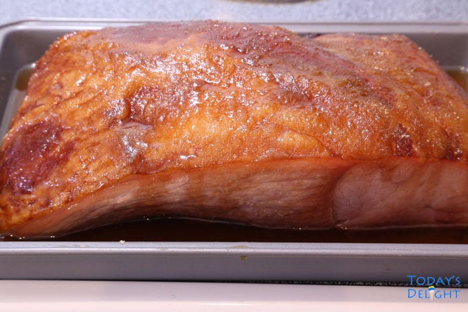 Fully cooked carve ham with glaze on a tray.