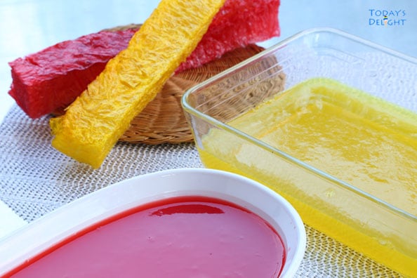 Two sticks of yellow and red gulaman not made and yellow and red gulaman already made in separate containers.