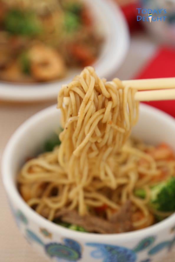 A bowl of lo mein and chop stick with noodles.
