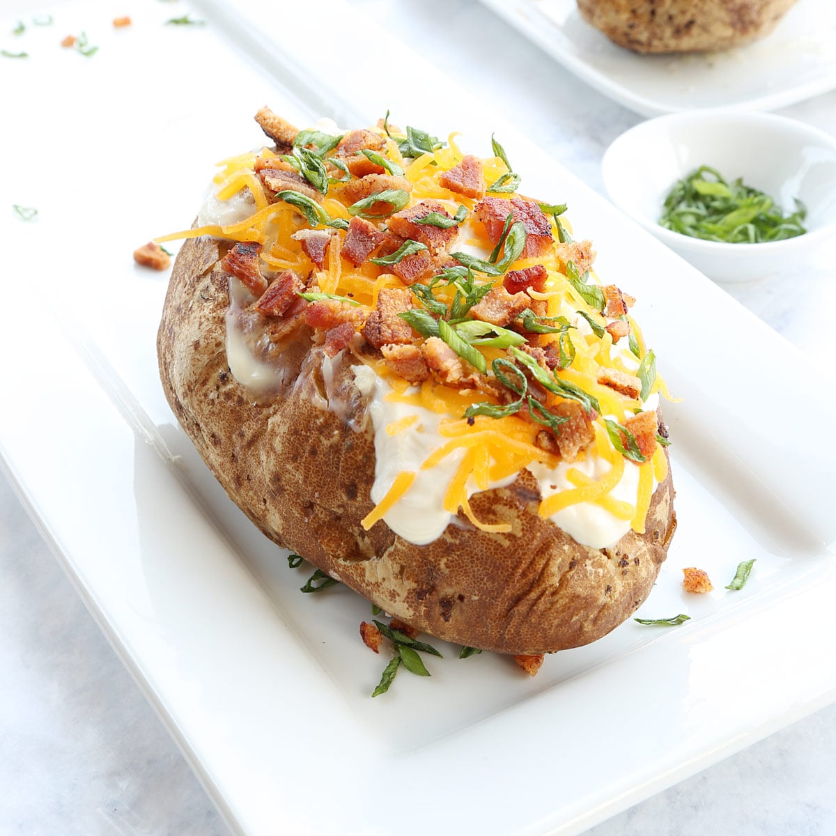 Bake potato with sour cream and toppings like cheese, bacon and chives.