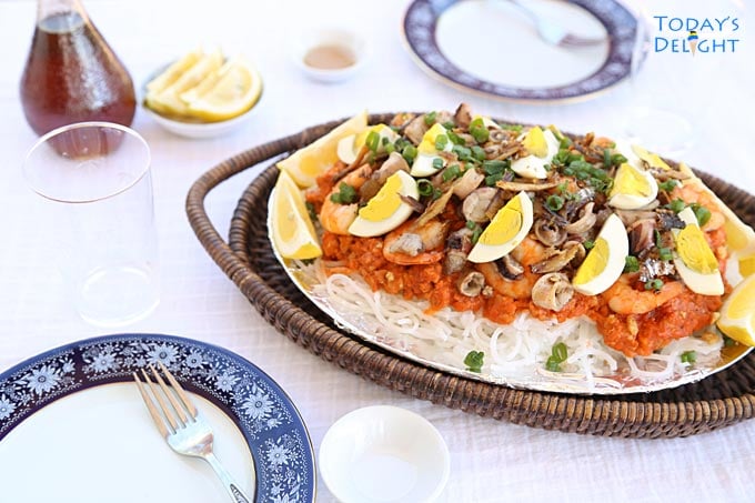 Tray of Pancit Luglug with plates, slices of lemon & fish sauce
