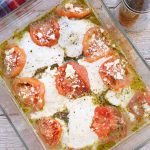 Baked Chicken Pesto with Tomato Mozzarella and Feta Cheese in a pyrex pan.
