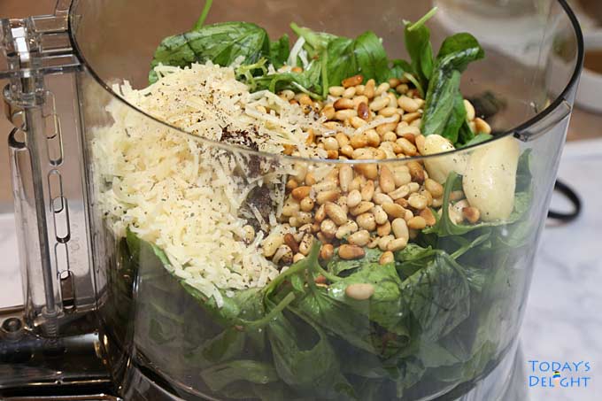 Ingredients in food processor to make basil pesto sauce.