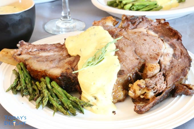 Slice of well-done ribeye roast with bearnaise sauce