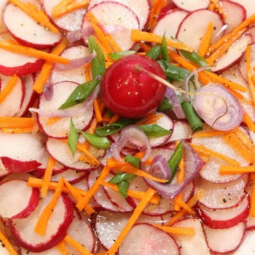 Asian salad with carrot, radish, green onion, and shallot in sweet savory sauce.