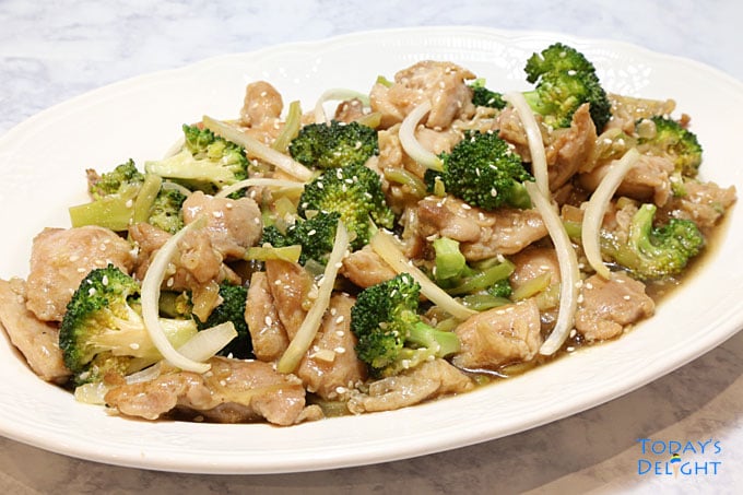 Sauteed chicken and broccoli flavored with savory oyster sauce garnished with onions and sesame seeds in a platter.