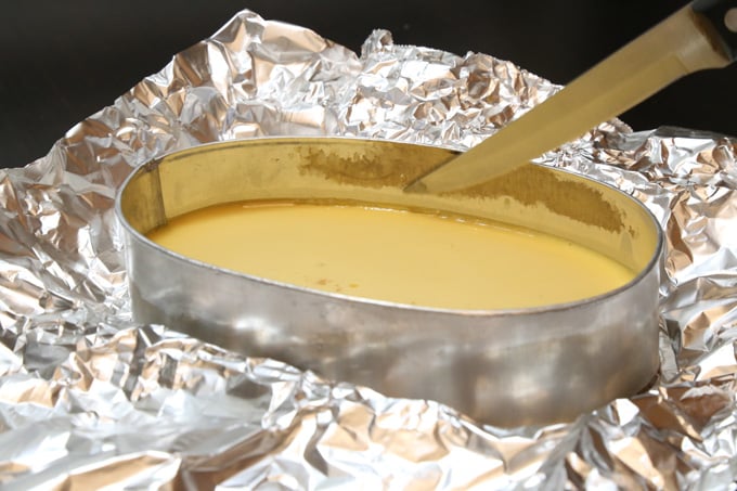 A knife is used around the edges to detach flan from pan. Pan on top of a foil.