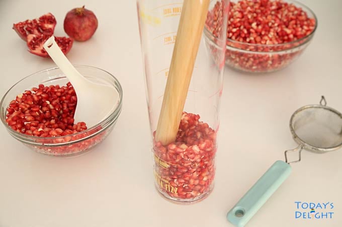 Compress pomegranate seeds using a muddler.