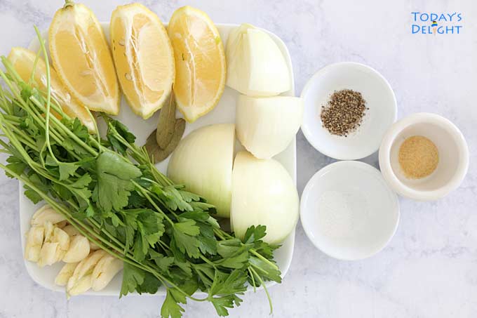 Stuffing ingredients (lemon, garlic, parsley, onion, bay leaves and seasoning in the lower cavity of turkey.