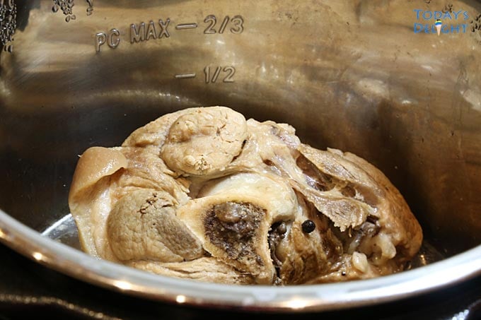Cooked pork hock with water and peppercorn in an instant pot.