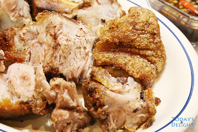 Chopped crispy pata - fried pork leg in a platter with a side of spicy vinegar sauce.