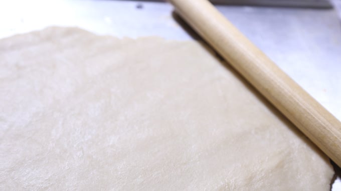 Flatten pie crust with rolling pin.