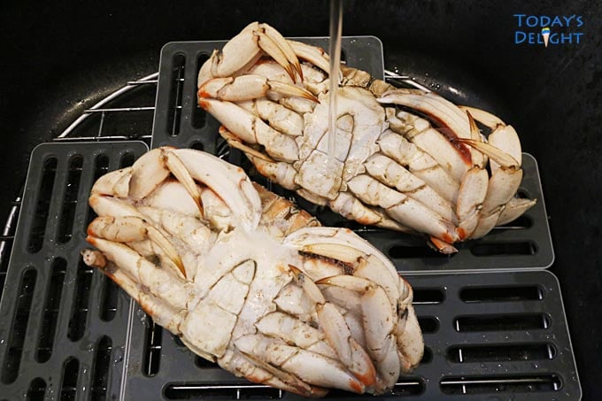 Wash dungeness crab in sink.