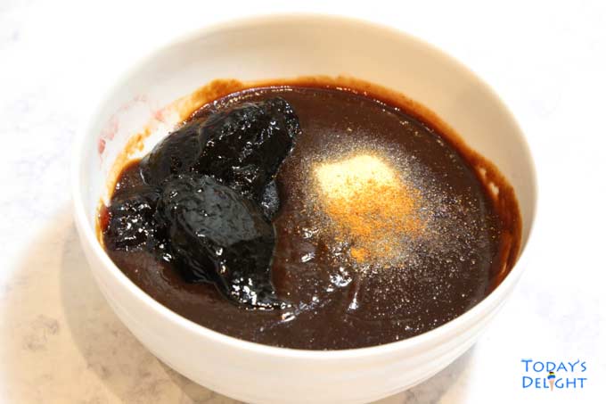 Combined barbecue sauce, grape jelly, garlic powder and cayenne pepper in a bowl.