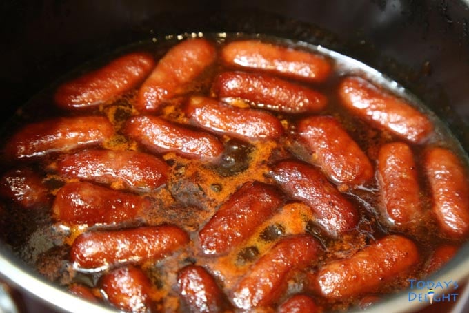 Lil smokies and barbecue sauce mixture cooked on stove top.