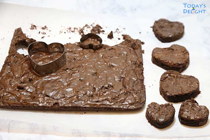 Cutting brownie with heart shaped cookie cutter.