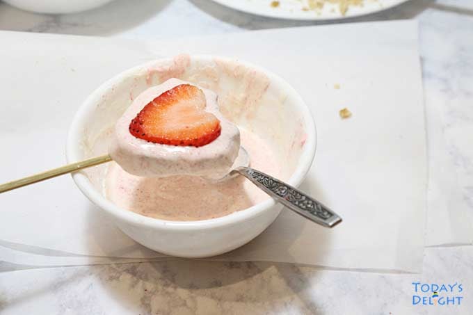 Fresh thin sliced strawberry is placed on brownie.