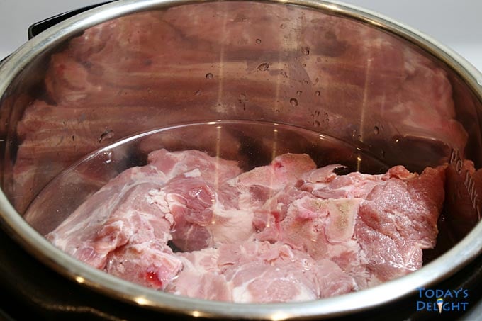 Pork neck bones in instant pot with water.