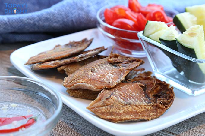 Cooked dried fish served with diced tomatoes and cucumber.