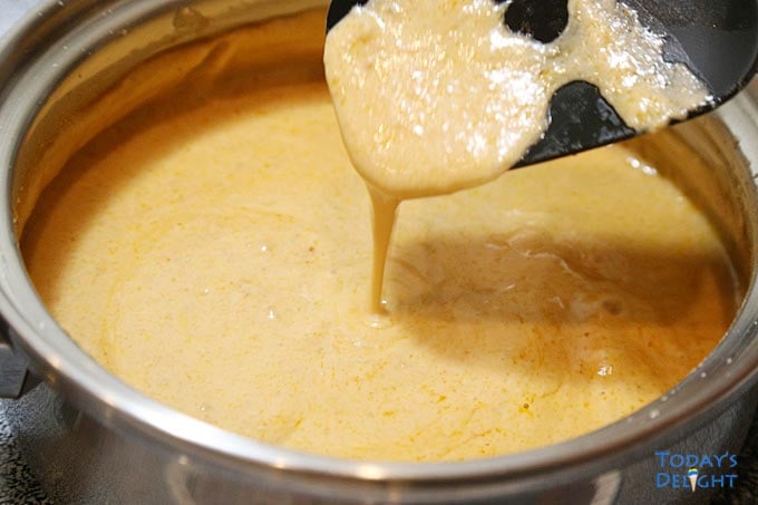 Checking with ladle if peanut sauce is thick already.