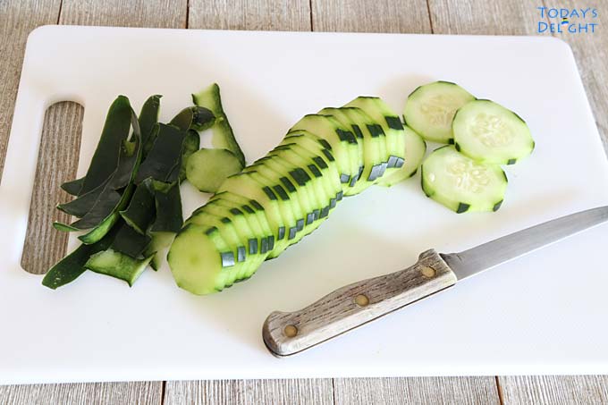 Sliced cucumber on a cutting board and a knife..