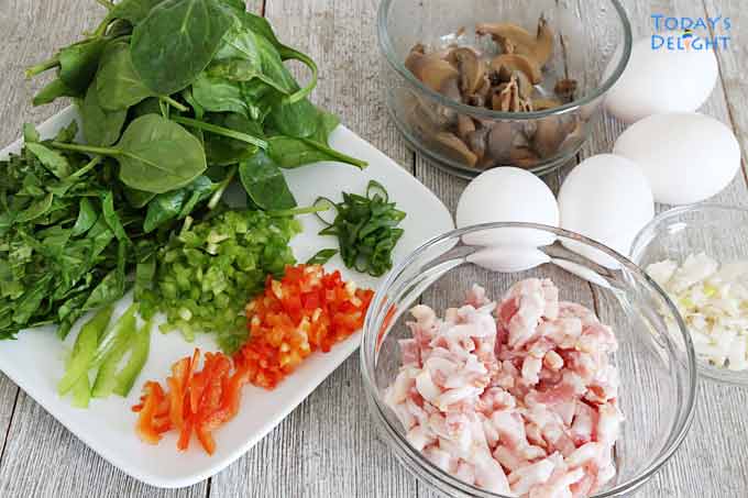 Ingredients to make omelette are spinach, mushroom, red and green peppers, onion, and eggs.